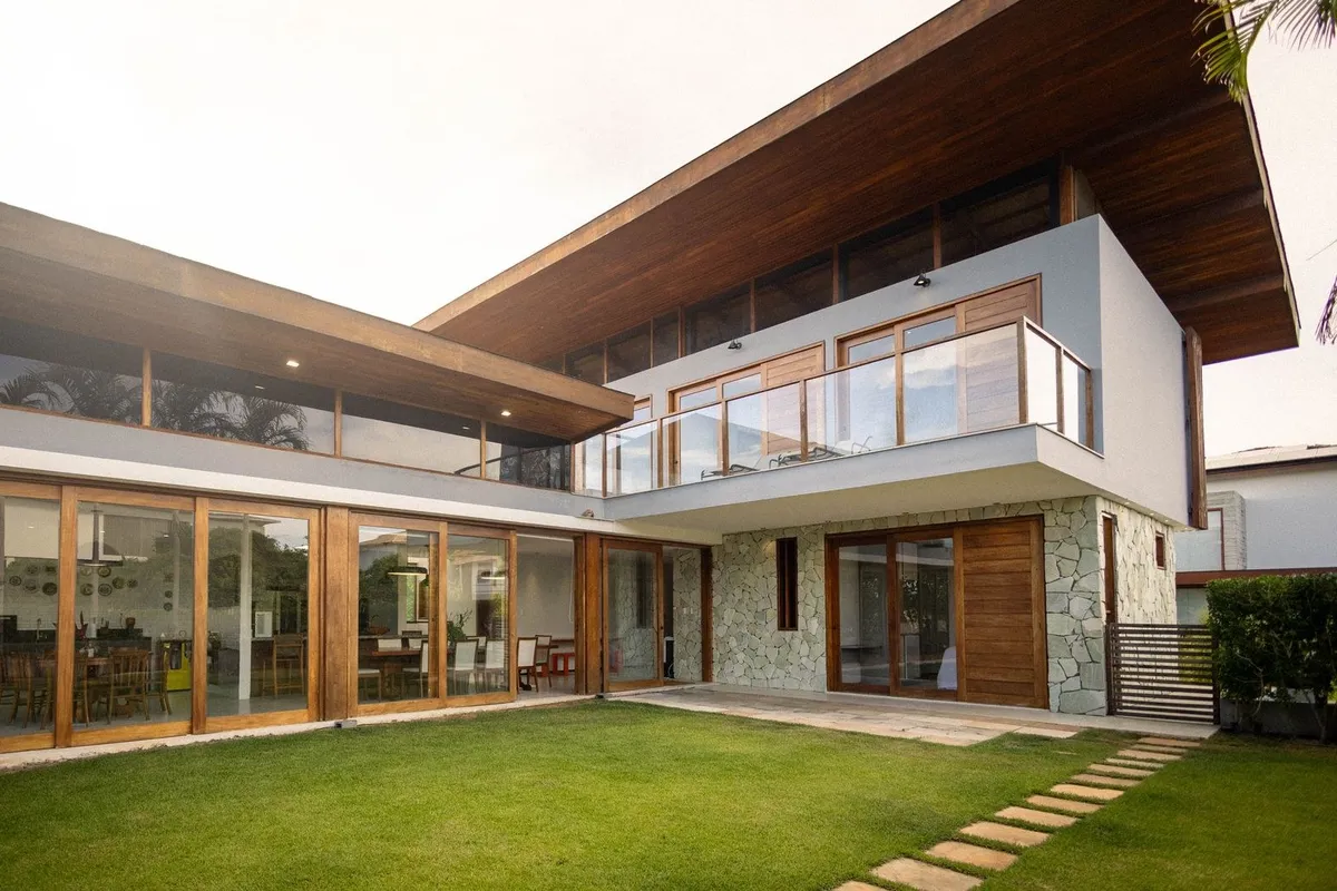 A modern luxury house with large glass windows and wooden accents, highlighting the importance of quality materials.